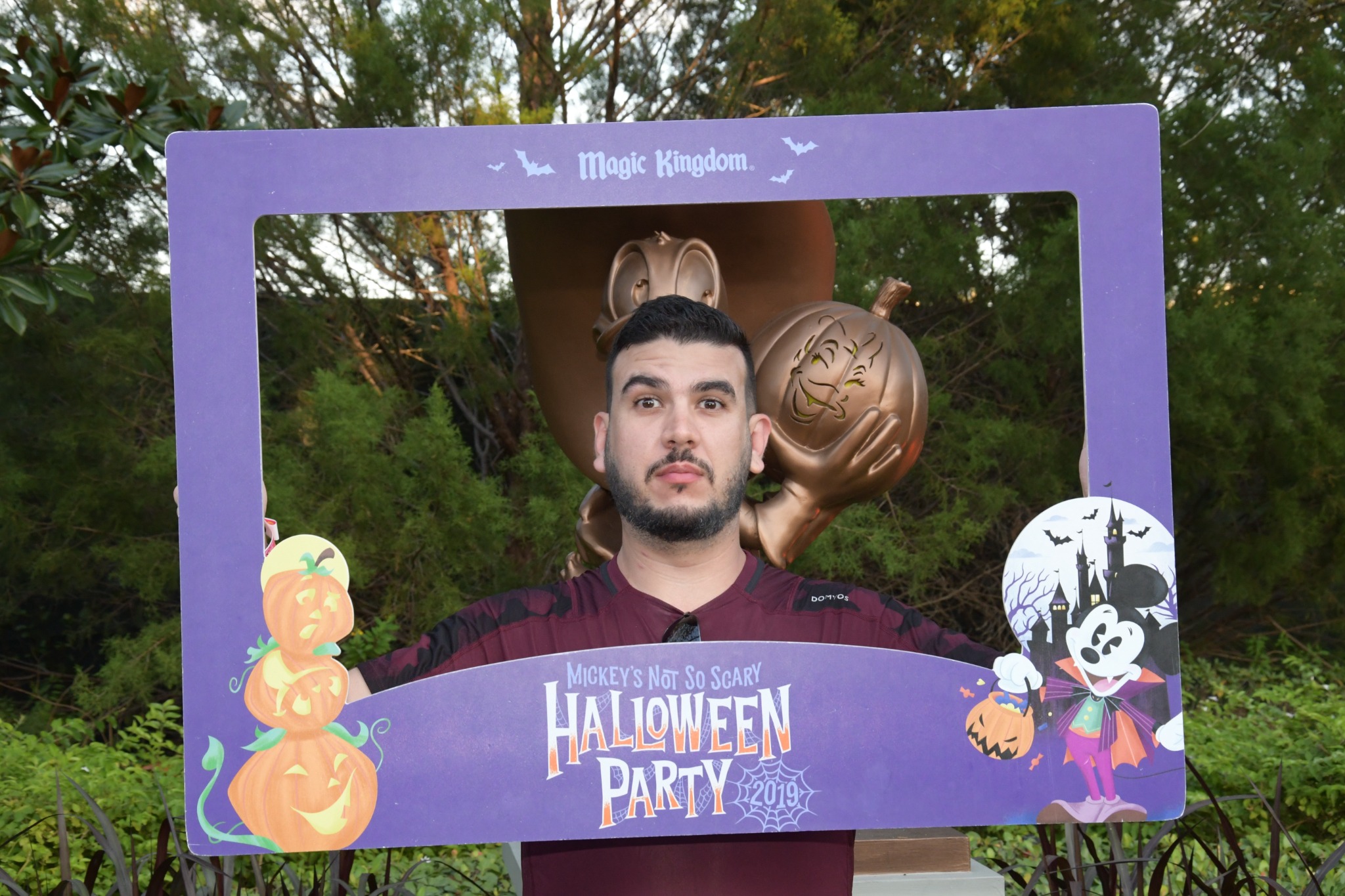 Visitante posa em uma moldura temática de Halloween no Magic Kingdom em 2019.