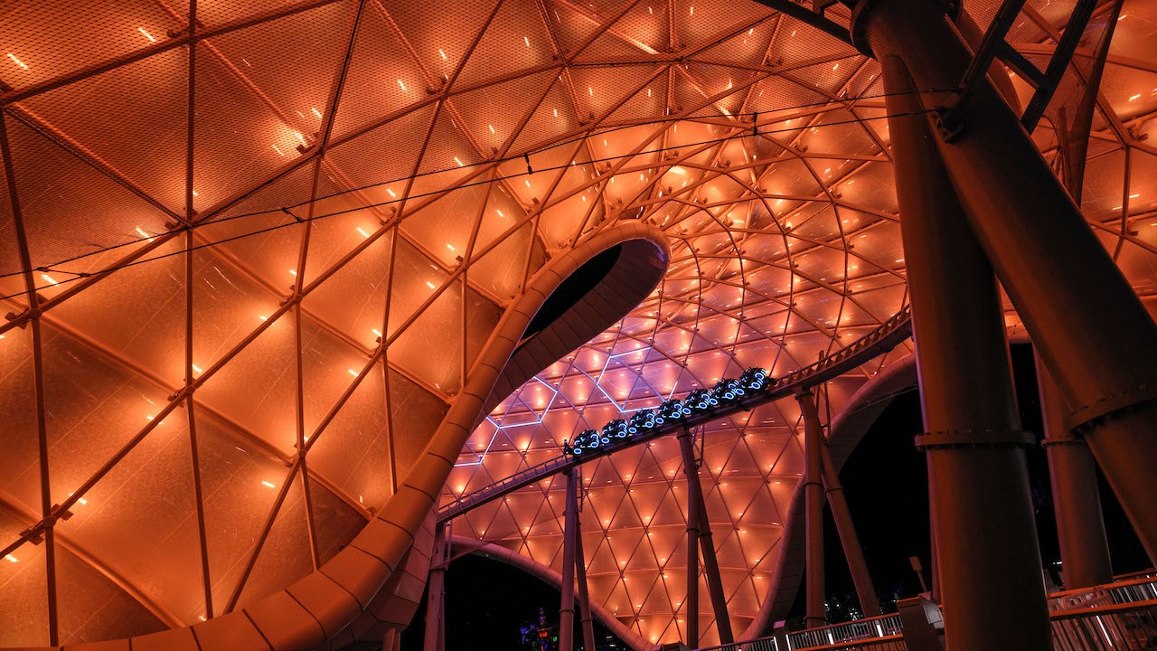 Trem de TRON Lightcycle / Run passa sob a cobertura iluminada da atração no Magic Kingdom.
